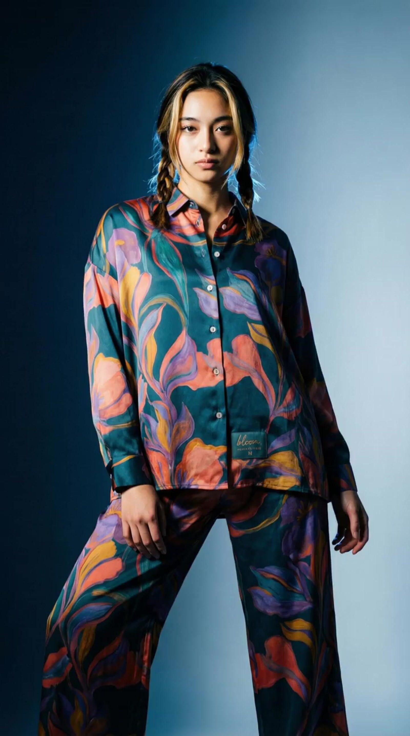 a woman in a colorful shirt and pants