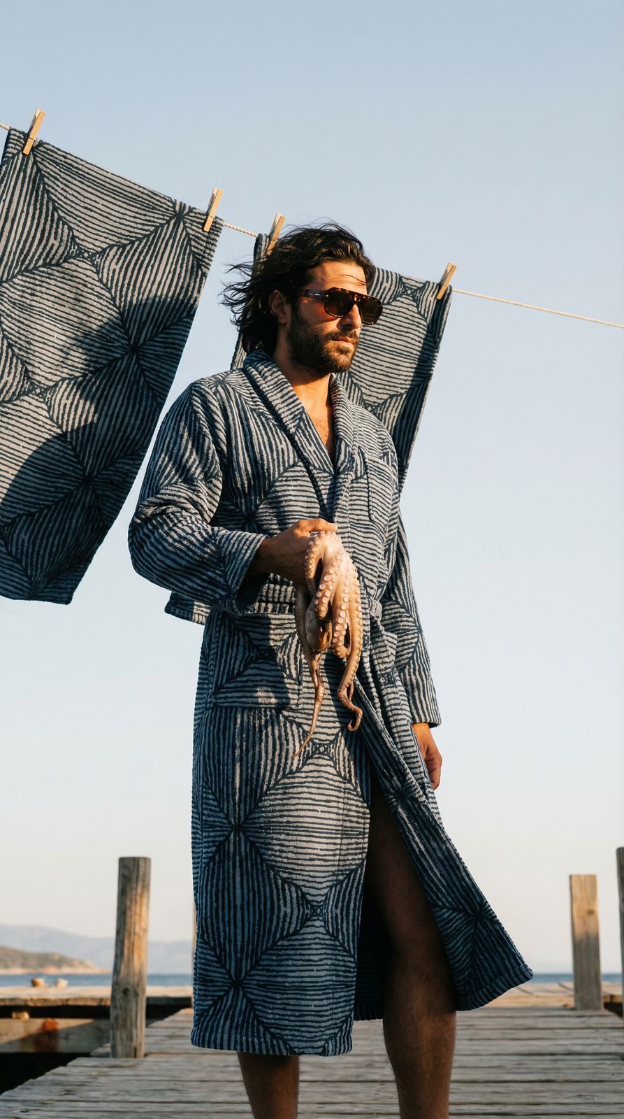 a man in a bathrobe holding two umbrellas