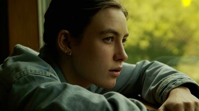 a woman sitting at a table looking out a window