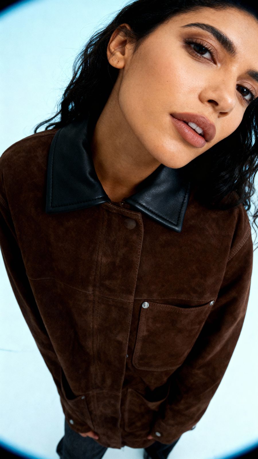 a woman wearing a brown jacket and black boots