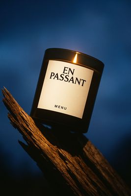 a lit candle sitting on top of a piece of wood