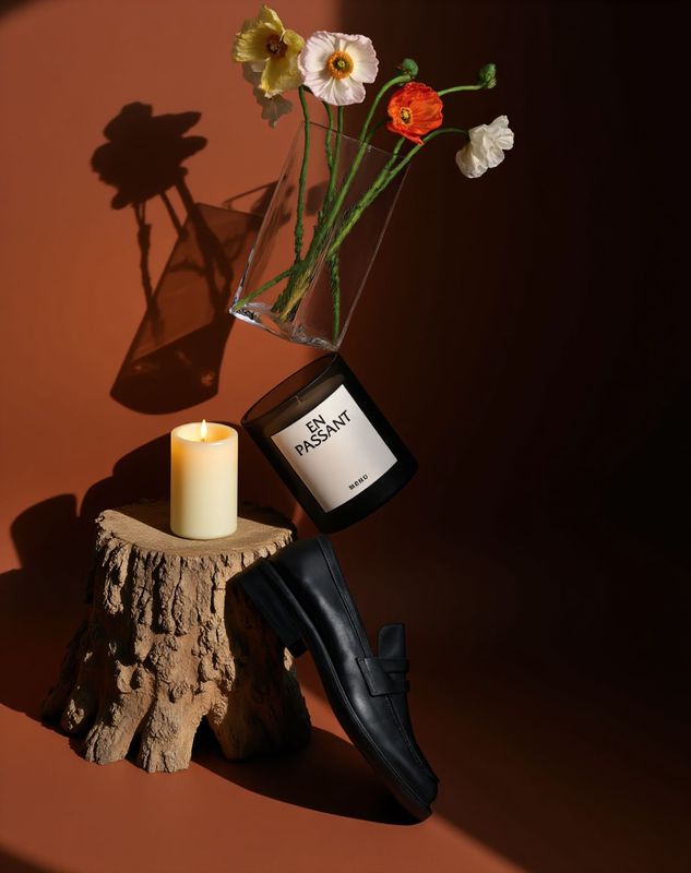 a vase with flowers and a candle on a stump