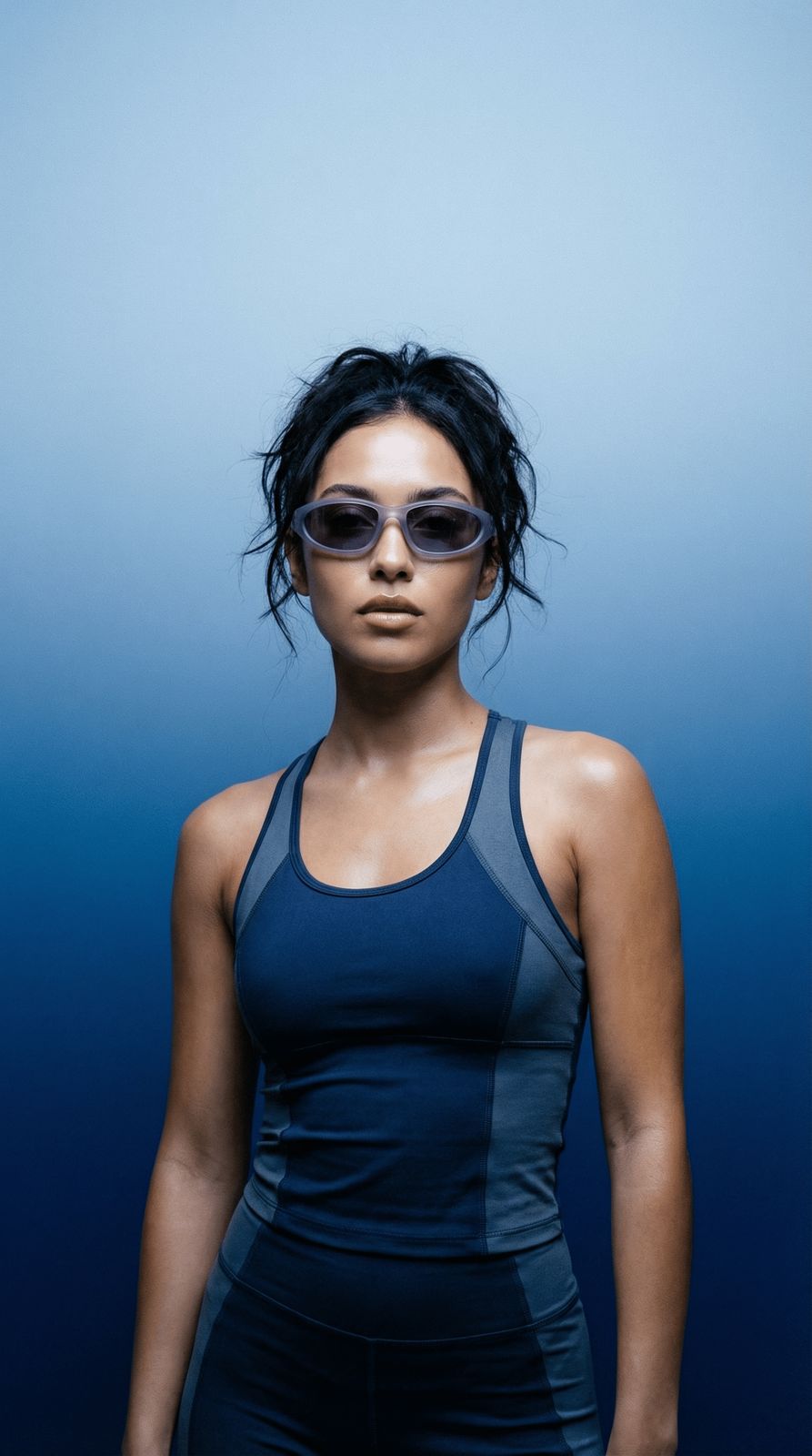 a woman in a blue tank top and sunglasses