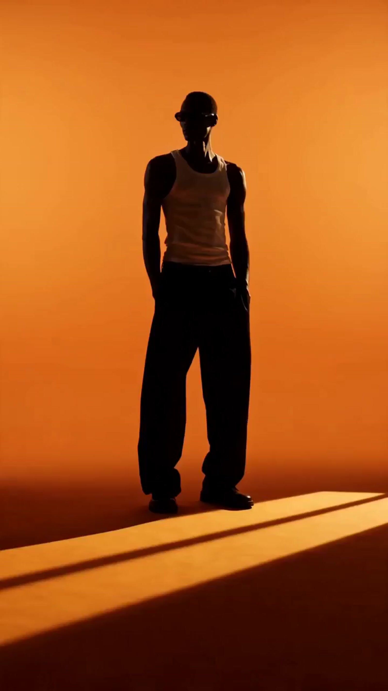 a man standing in the shadows of an orange wall