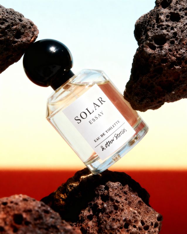 a bottle of perfume sitting on top of a rock