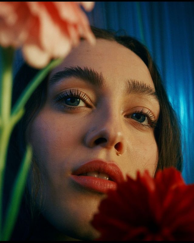 a close up of a person holding a flower