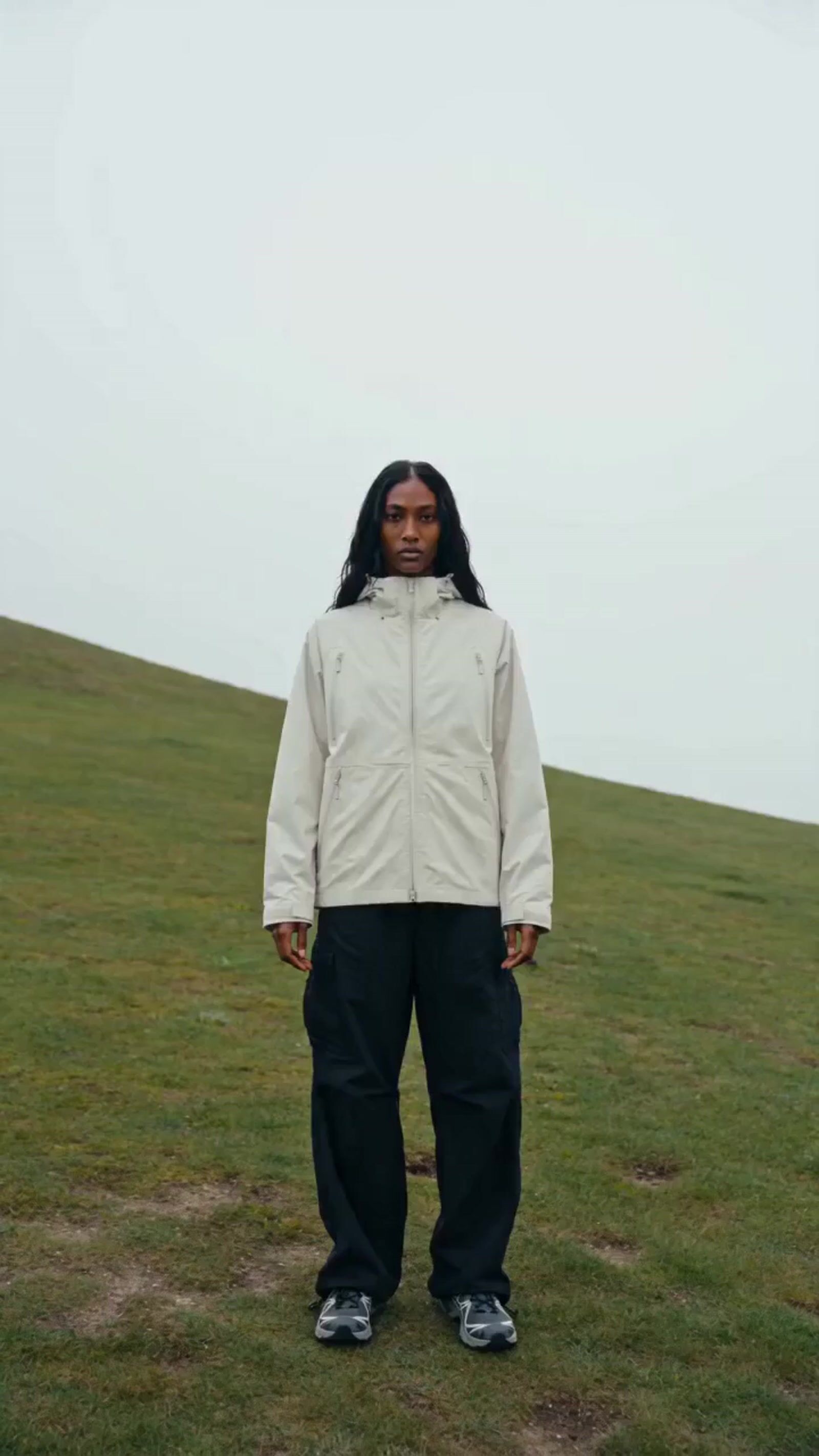 a person standing on a grass covered hill
