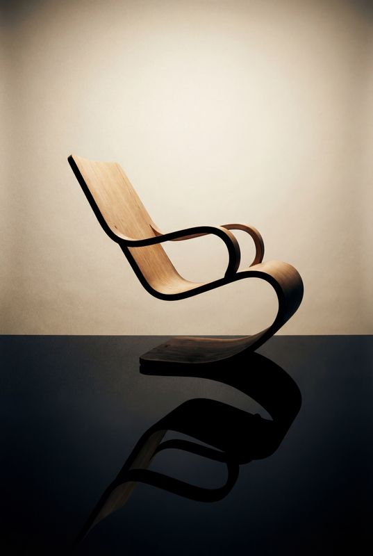 a wooden chair sitting on top of a black table