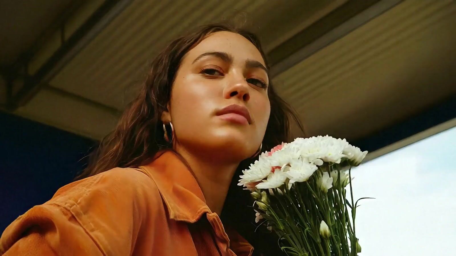 a woman holding a bouquet of white flowers