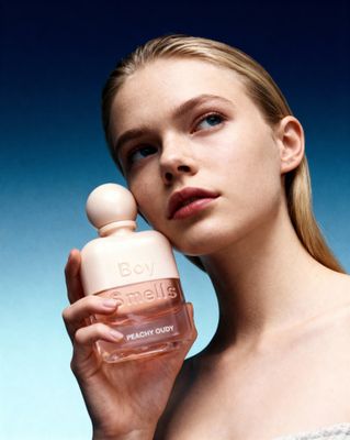 a woman holding a bottle of perfume in her hand