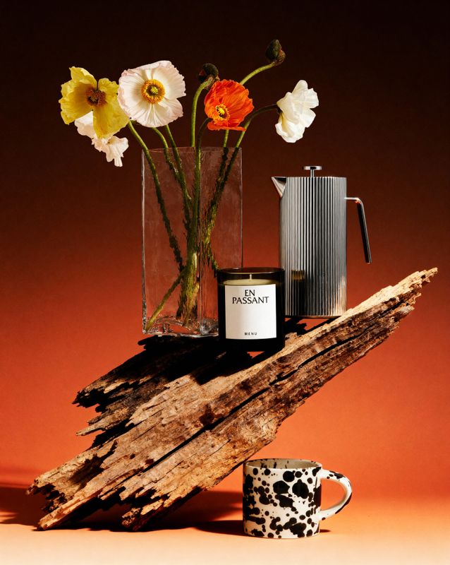 a vase of flowers sitting on top of a piece of wood