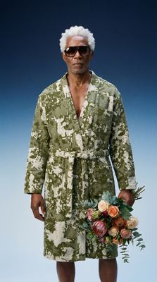 a man in a bathrobe holding a bouquet of flowers