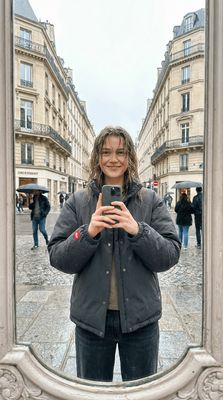 a woman taking a selfie in front of a mirror