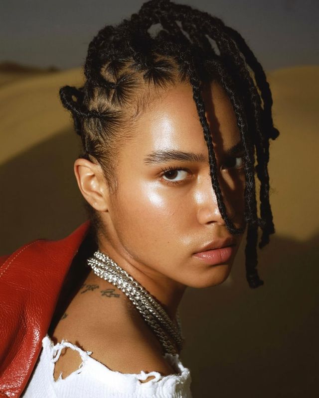 a woman with dreadlocks and a red jacket