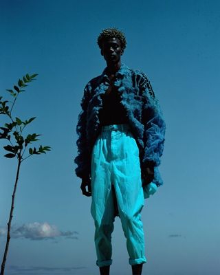 a statue of a man standing next to a tree