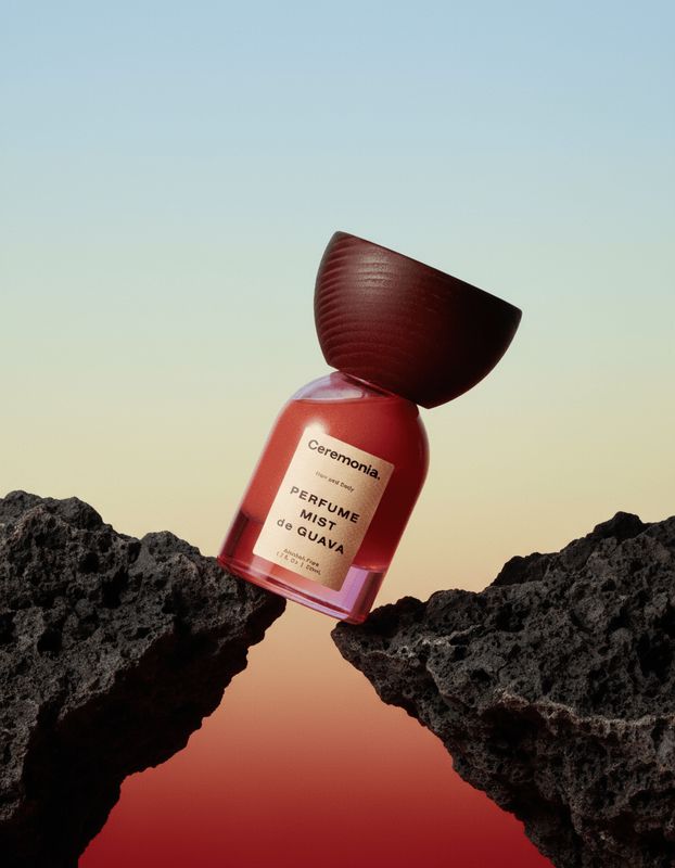 a bottle of perfume sitting on top of a rock