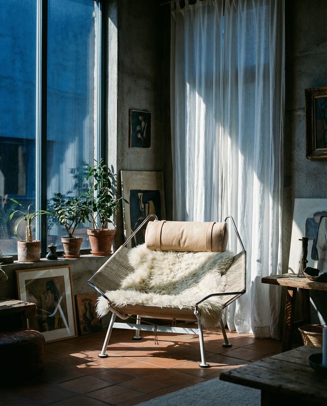 a living room with a chair and pictures on the wall