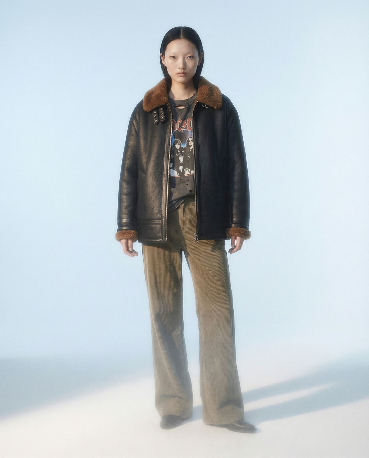 a woman in a black jacket and brown pants