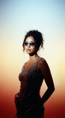 a woman in a dress and sunglasses posing for a picture