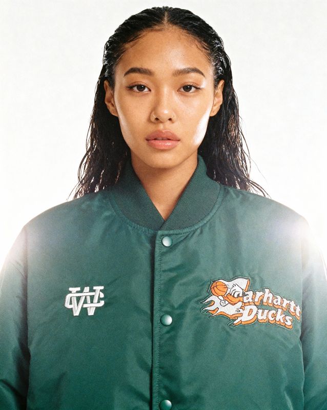 a woman with long hair wearing a green jacket