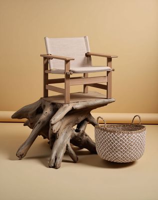 a chair sitting on top of a tree stump next to a basket
