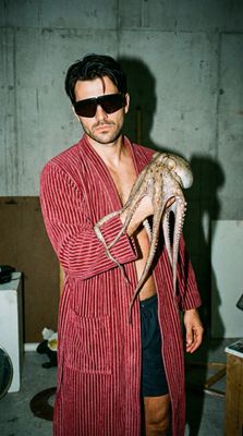 a man in a bathrobe holding an octopus