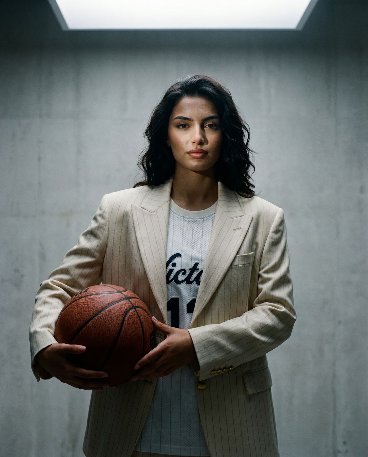 a woman in a suit holding a basketball