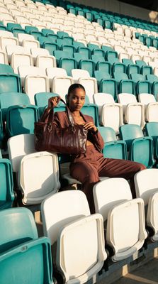 a woman sitting on a chair in a stadium