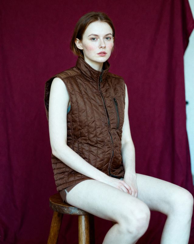 a woman sitting on top of a wooden stool