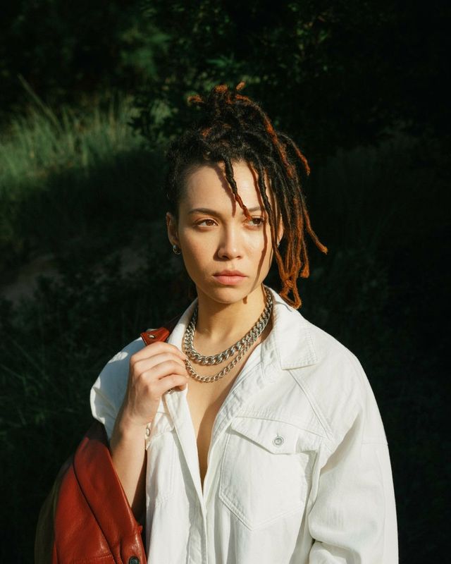 a woman with dreadlocks and a white shirt