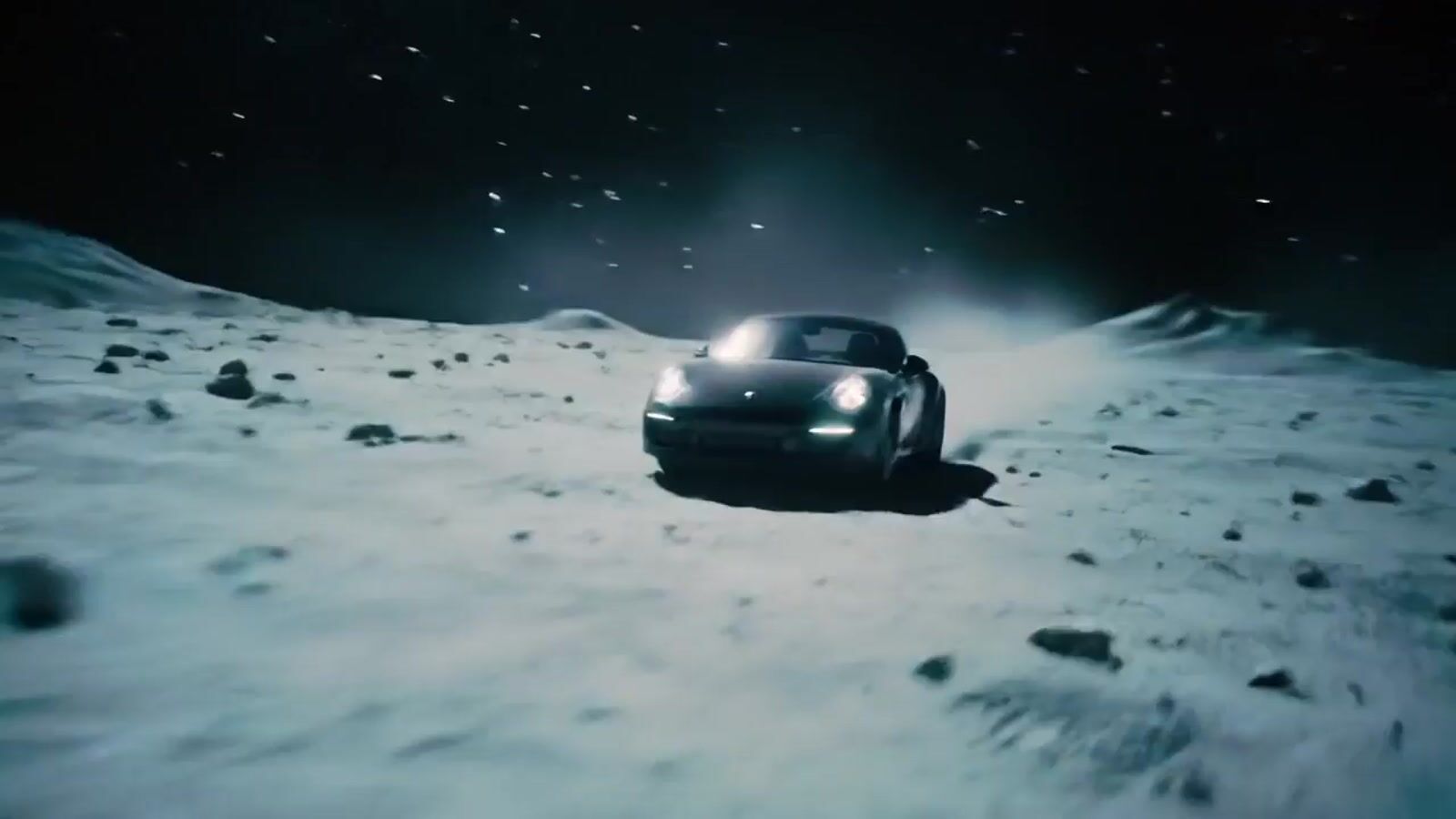 a car driving on a snowy surface at night