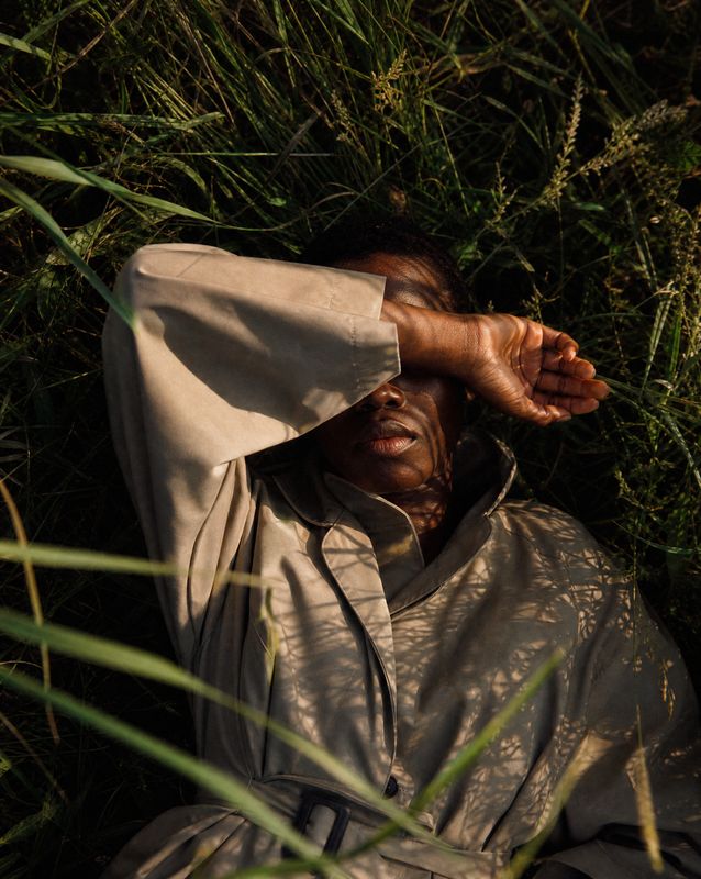 a man laying in the grass with his hands on his head