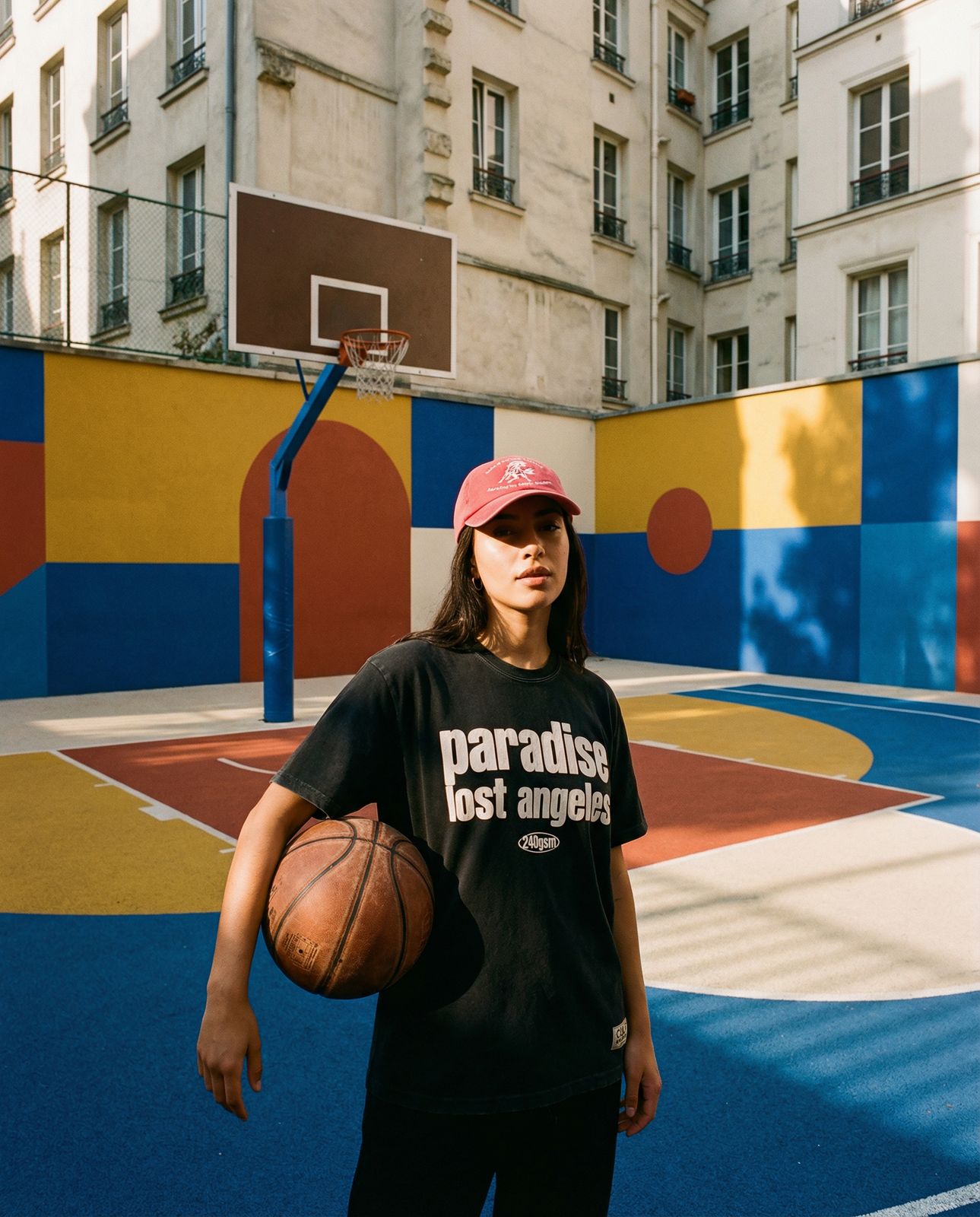 a woman holding a basketball in front of a basketball court