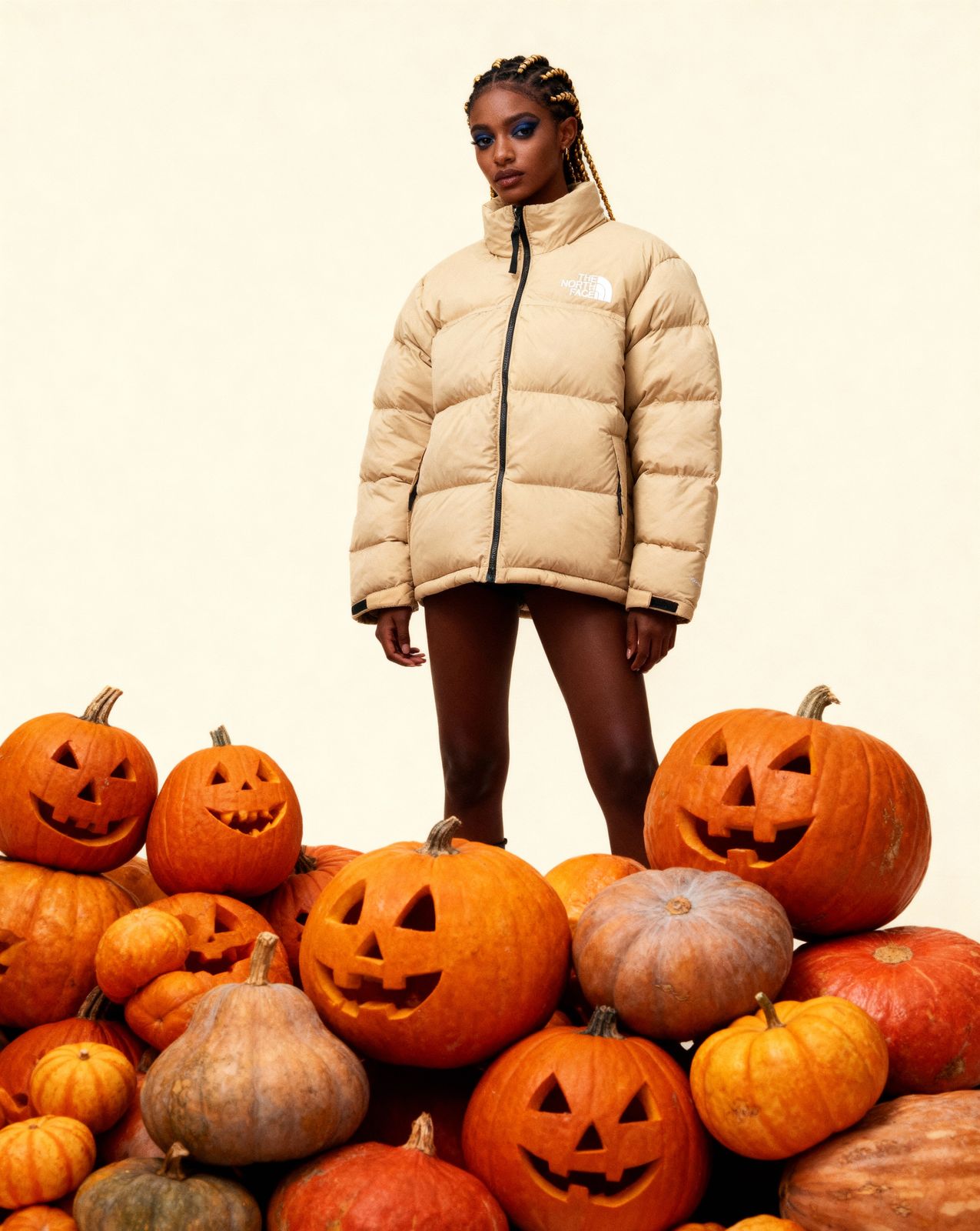 a woman standing on top of a pile of pumpkins
