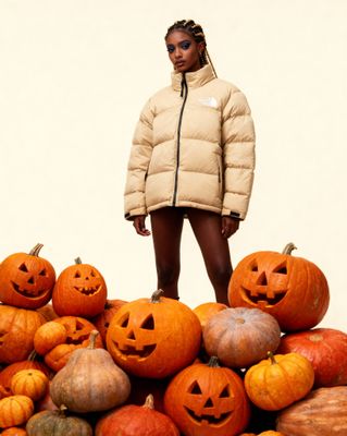 a woman standing on top of a pile of pumpkins