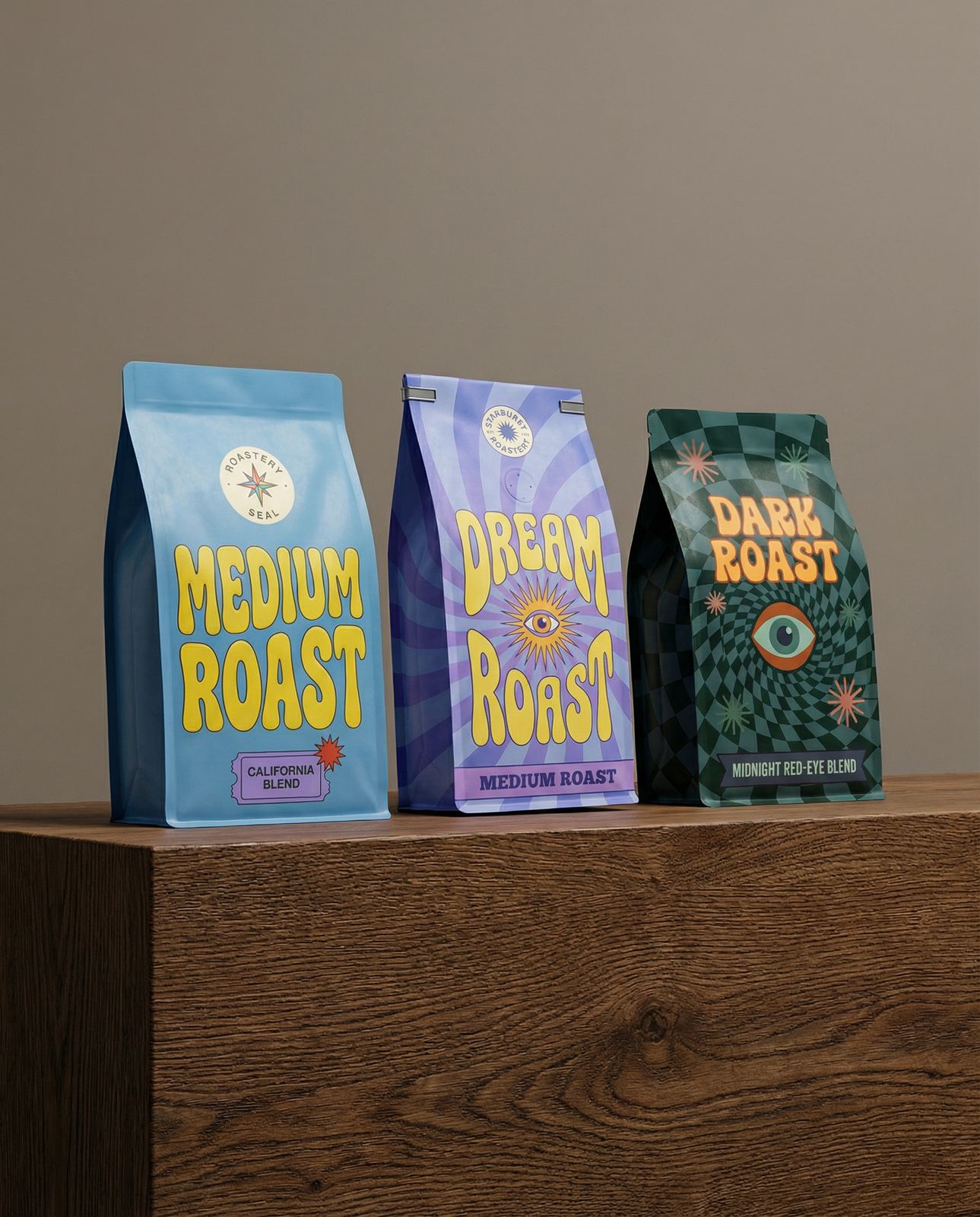 three bags of coffee sitting on top of a wooden table