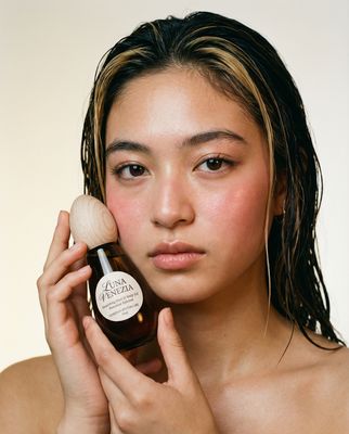 a woman holding a bottle of argan hair oil