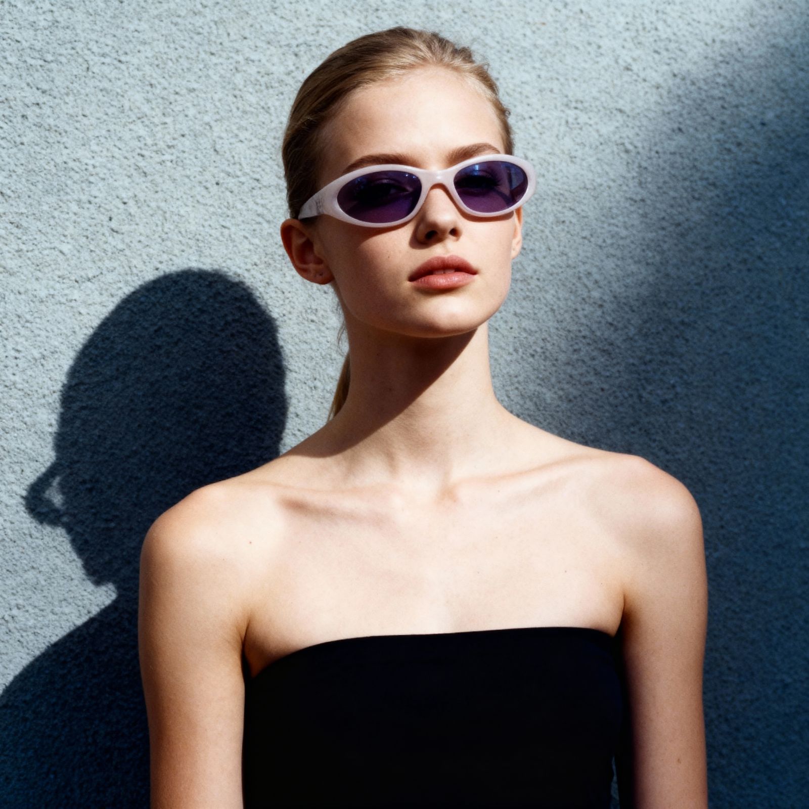 a woman in a strapless top and sunglasses