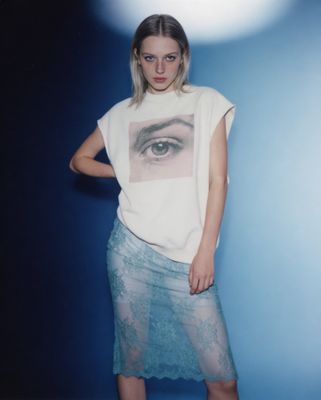 a woman standing in front of a blue background