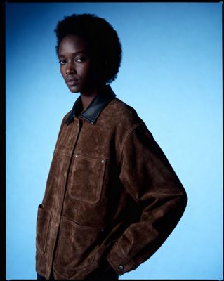 a man in a brown jacket posing for a picture