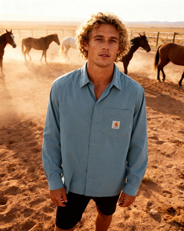 a man standing in front of a herd of horses