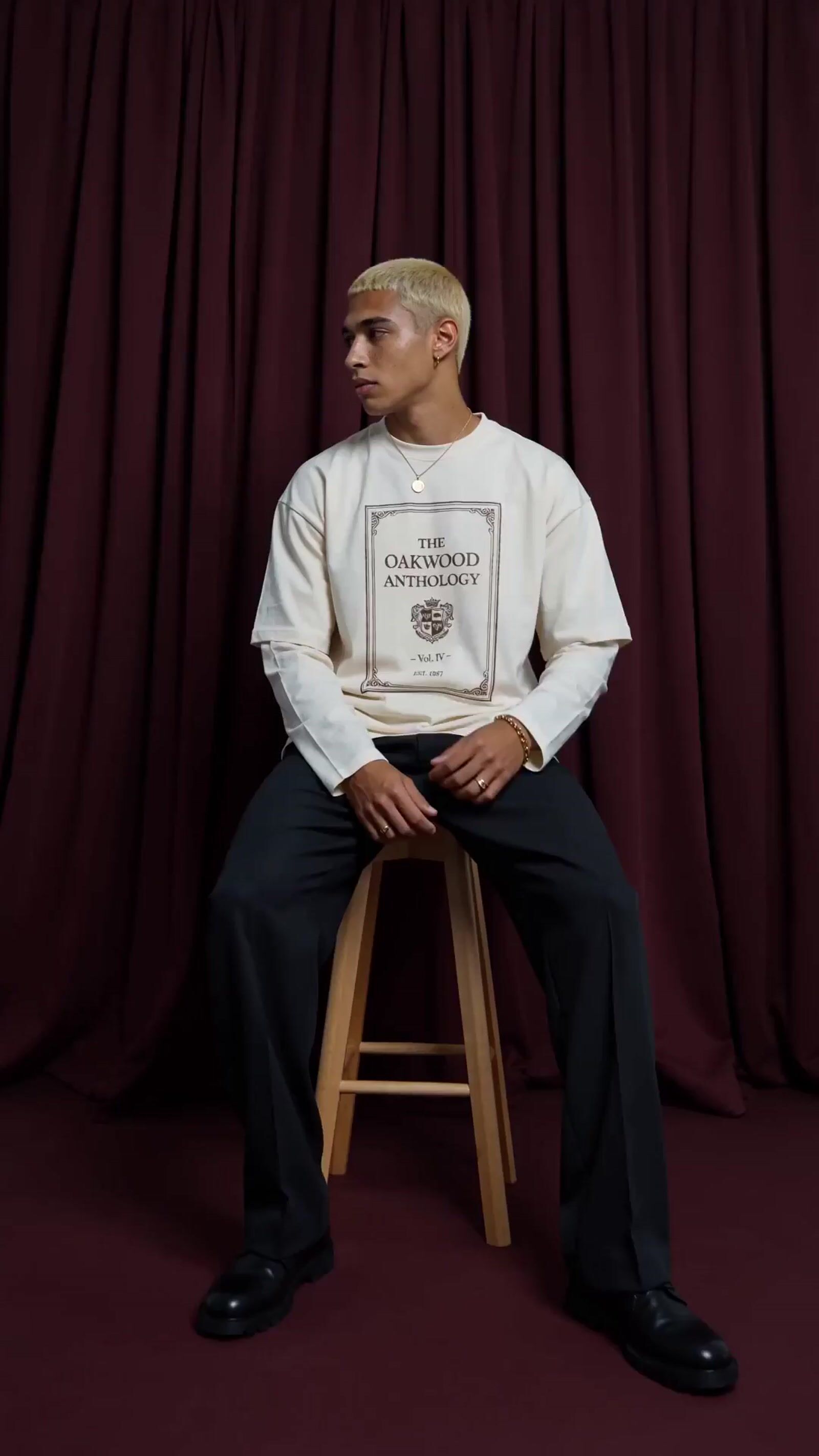 a man sitting on top of a wooden stool