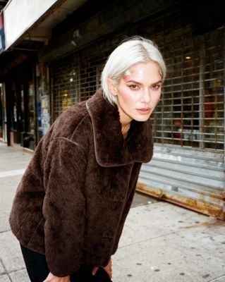 a woman standing on a sidewalk next to a building