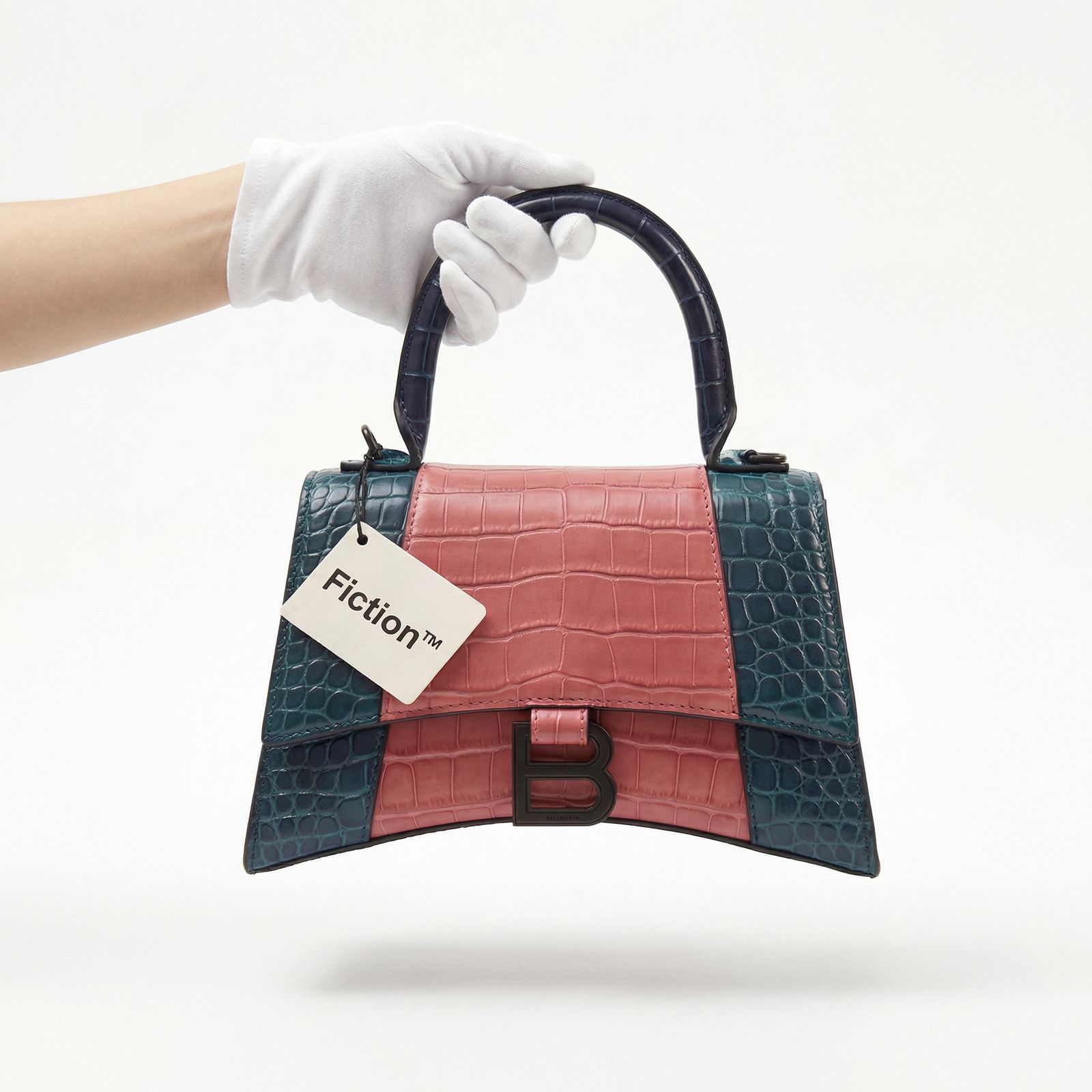 a hand holding a small purse with a tag on it