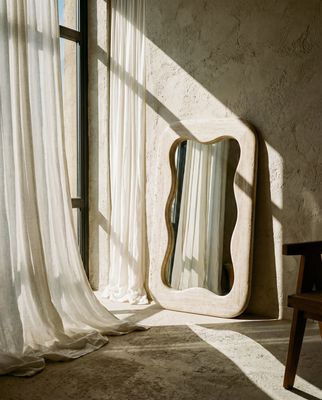 a mirror sitting on top of a table next to a window