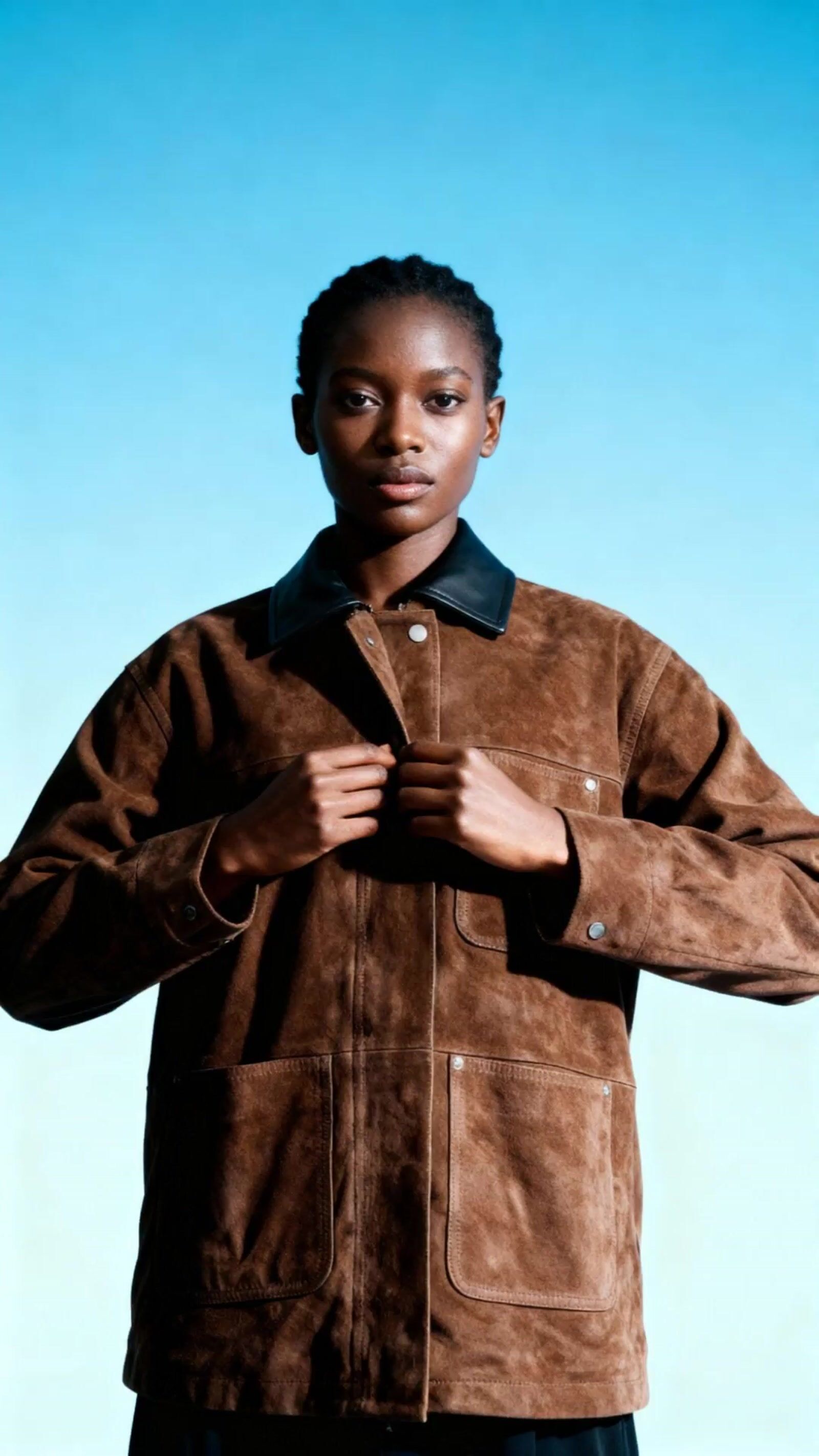 a man in a brown jacket is posing for a picture
