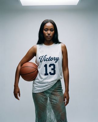 a woman holding a basketball in a white jersey