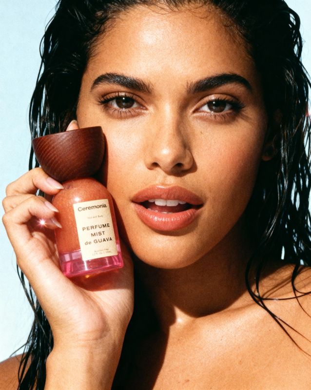 a woman holding a bottle of liquid in her hand