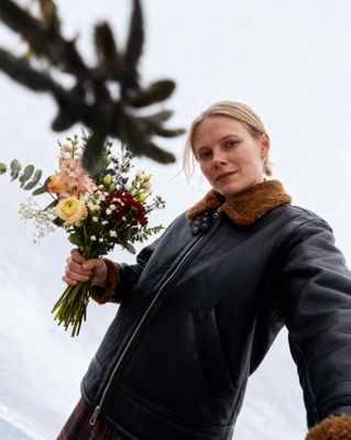 a woman is holding a bouquet of flowers
