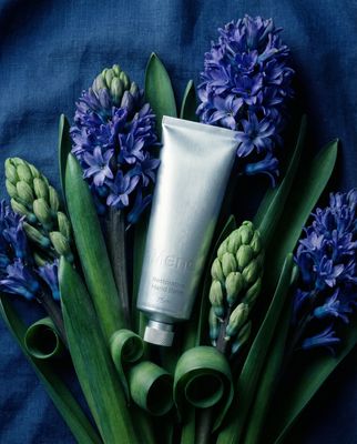 a tube of cream sitting on top of a bunch of flowers